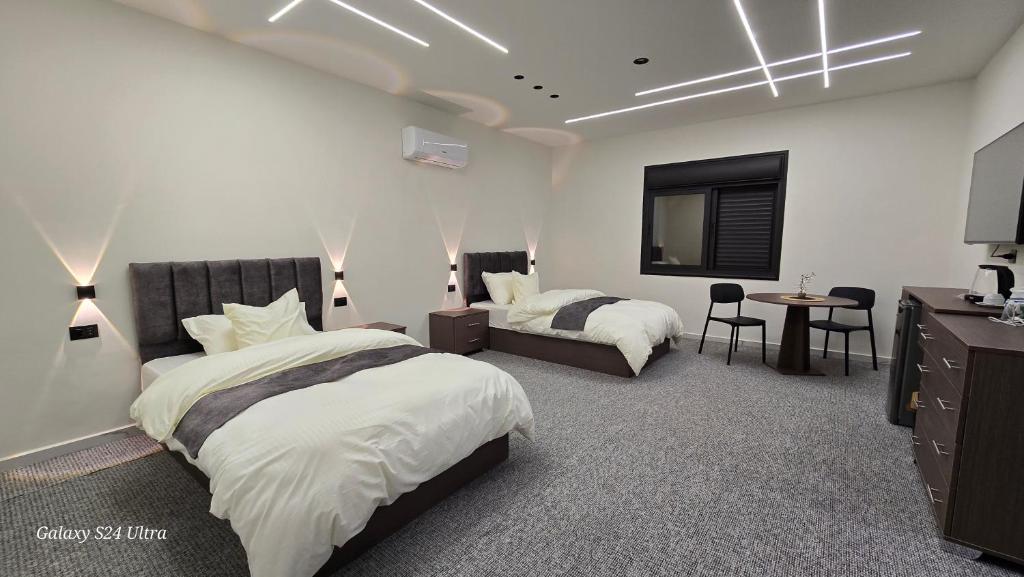 een slaapkamer met twee bedden en een flatscreen-tv bij Jeeso hotel in Jerash