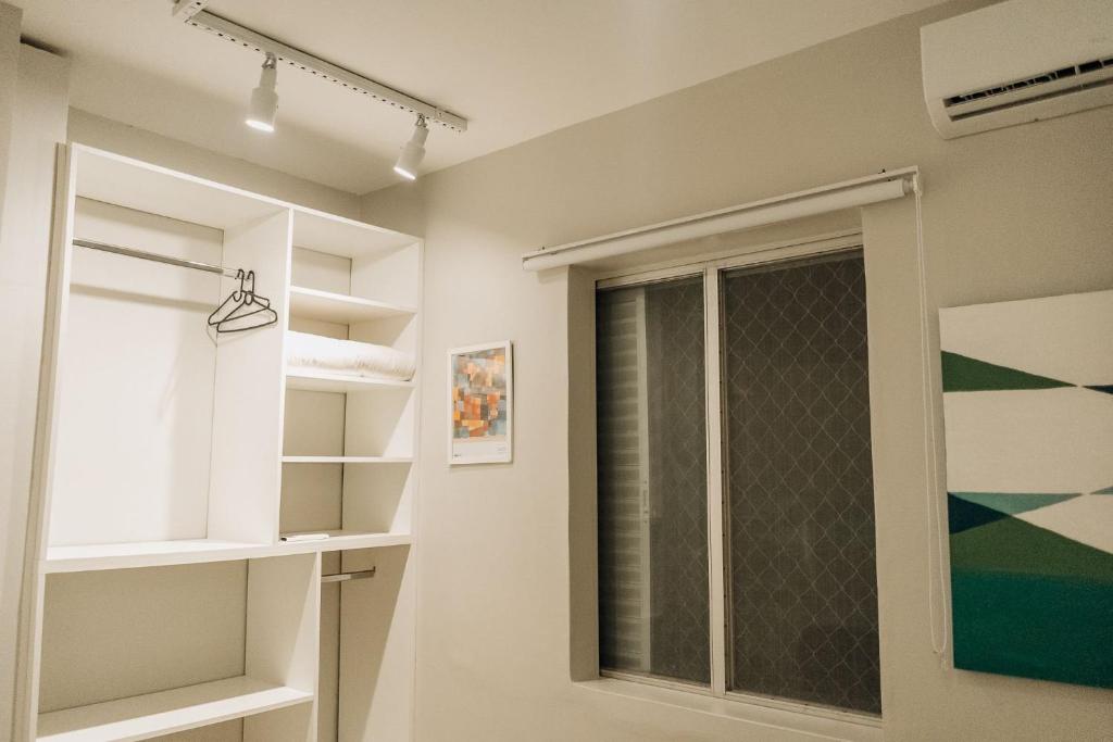 een badkamer met een raam en een spiegel bij Apartamento familiar com acesso privativo à Praia Mansa in Matinhos