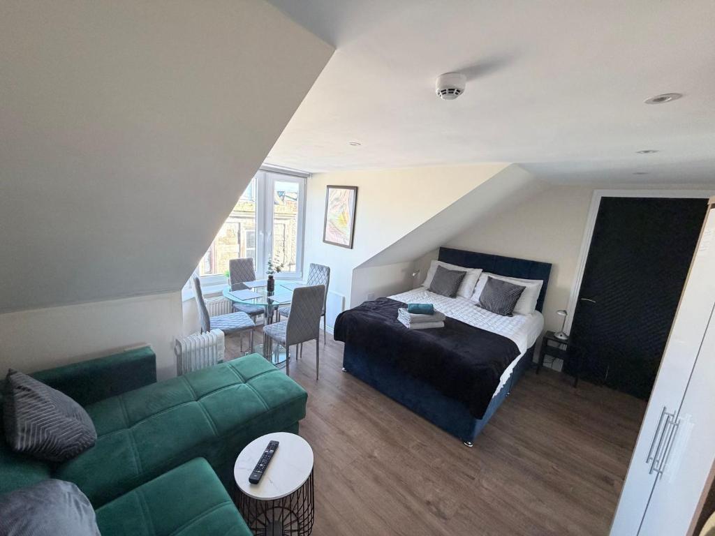 Un dormitorio con una cama y un sofá verde. en Apartment 5- 216 High Street, en Arbroath