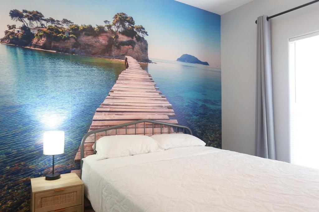 a bedroom with a painting of a pier in the water at Entire House - Spacious 3 Bedroom on the Island in Corpus Christi
