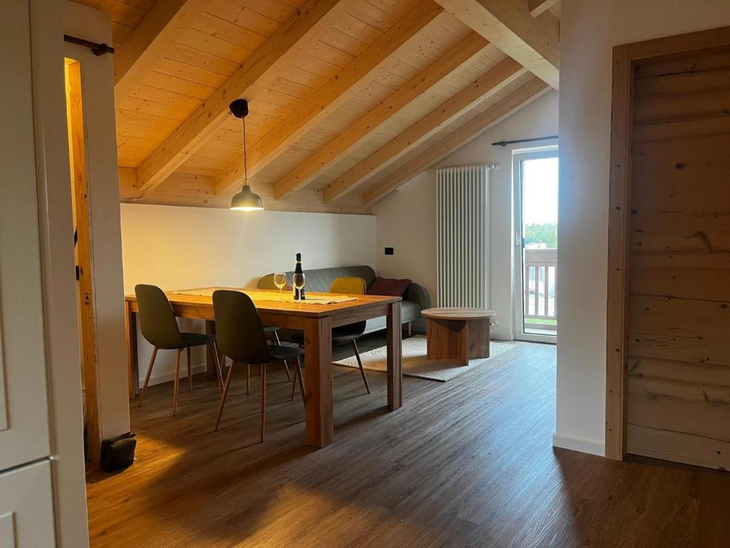 Un comedor con mesa y sillas de madera. en Appartamento La Téza, en Lavarone