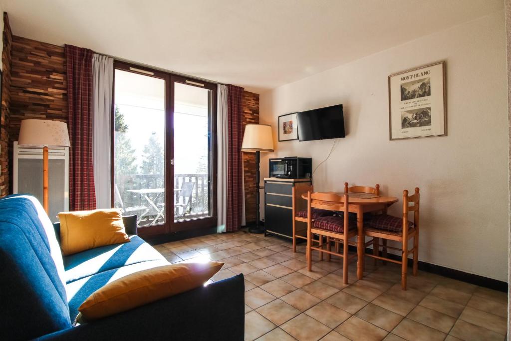 a living room with a couch and a table at Studio cabine lumineux et calme, au centre de Flaine Foret in Flaine