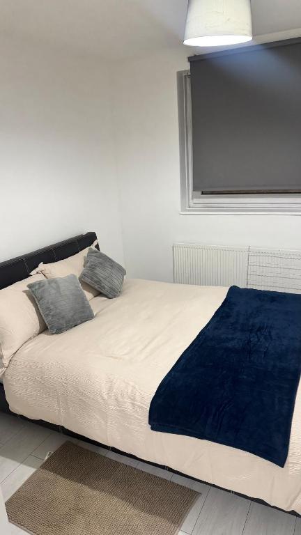 a bedroom with a bed with a blue blanket on it at Modern 1-Bed Flat in Crystal Palace Sydenham in Sydenham