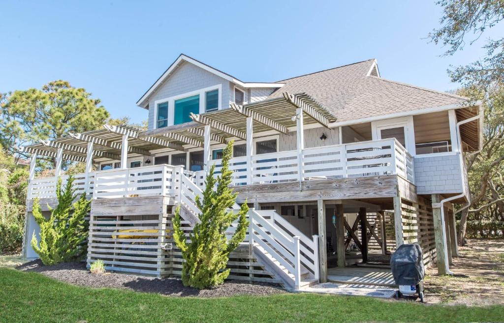 a house with a large deck on a beach at Family Tradition - Duck, Sanderling, Soundfront, Private Pier, Sunset Views, Community Pool, Pets OK in Duck