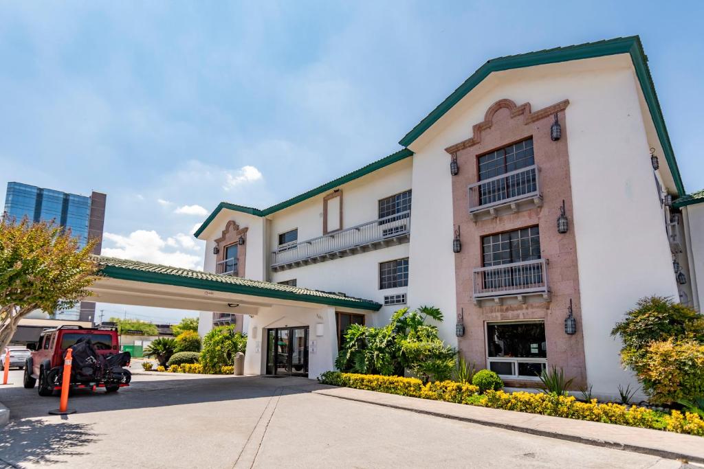 een gebouw met een auto ervoor geparkeerd bij Quinta Dorada Hotel & Suites in Saltillo