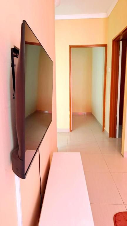 una TV appesa al muro di una stanza di LeGae Apartments a Gaborone