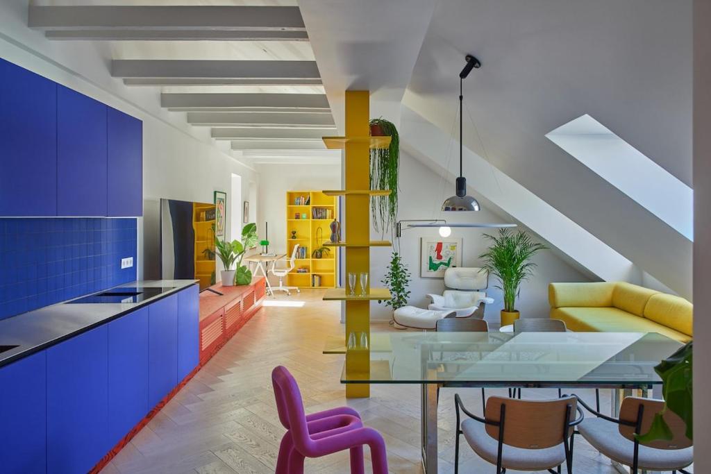 un soggiorno con un tavolo di vetro e sedie viola di Pop Haus Vilnius a Vilnius