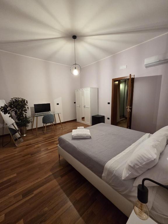 a bedroom with a large bed and a desk at La Dimora di Vittorio Emanuele II in Barletta