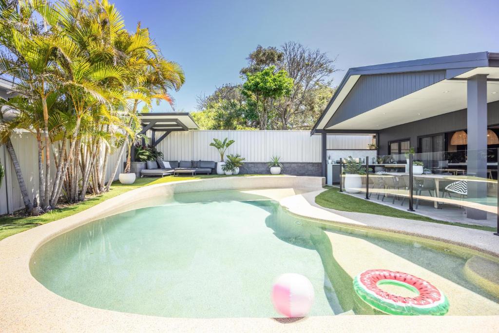 a swimming pool in the backyard of a house at Caves Coastal Escape in Swansea
