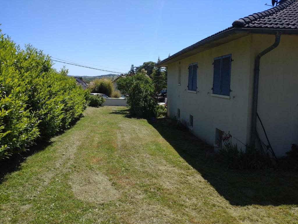 an empty yard next to a white house at La Vernoisienne dans le Jura in Le Vernois