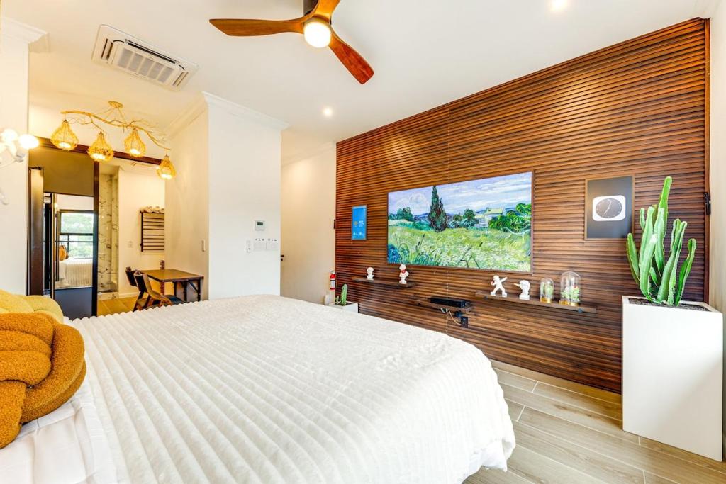 una camera con un letto bianco e una parete in legno di Home in Heart of Wilton Drive, 4 Mi to Beach a Fort Lauderdale