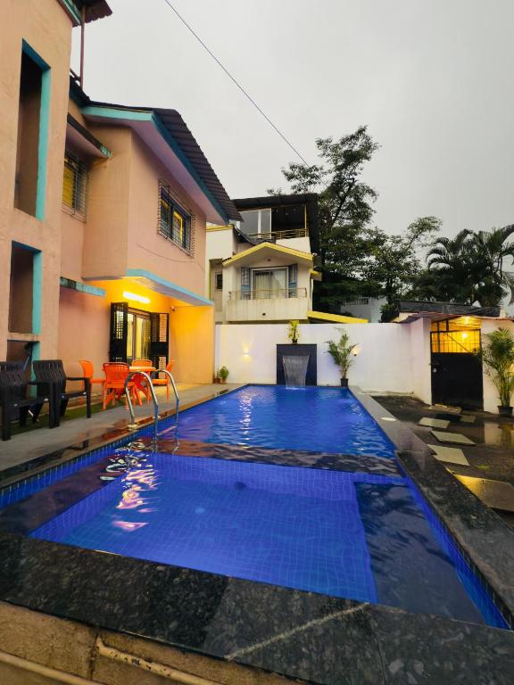 a large blue swimming pool in front of a house at Golden Maple Villa in Jāmb