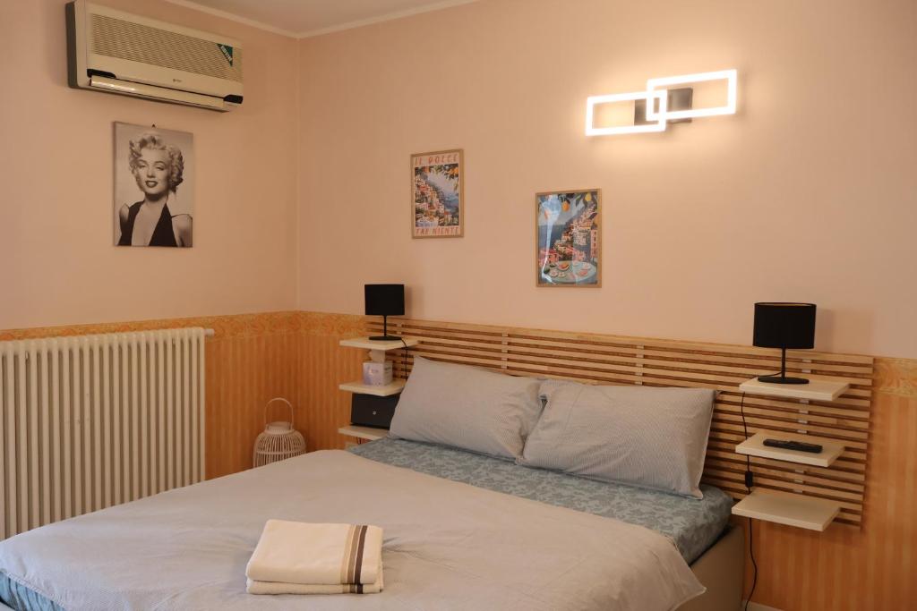 a bedroom with a bed with a wooden headboard at Maison Prestige in Monfalcone