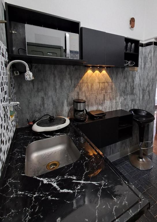 a kitchen counter with a sink and a microwave at Great central apartment in Duque de Caxias