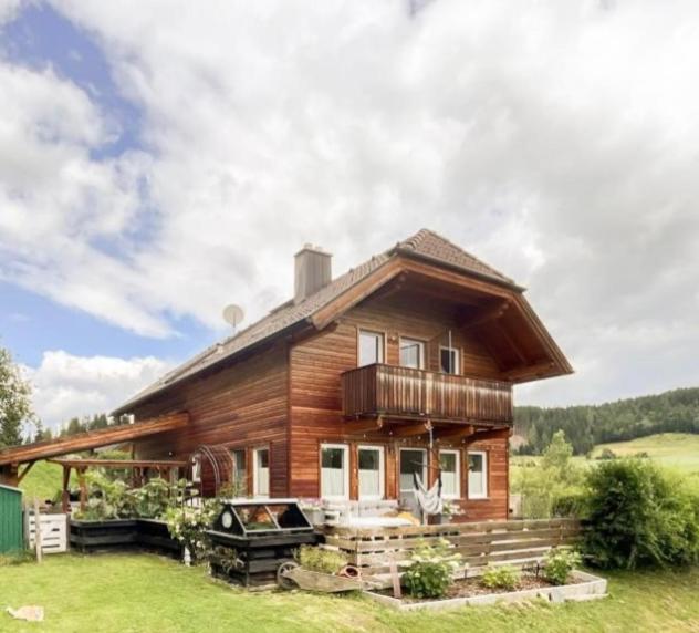 a large wooden house with a grill in front of it at Ferienwohnung Julia in Thomatal
