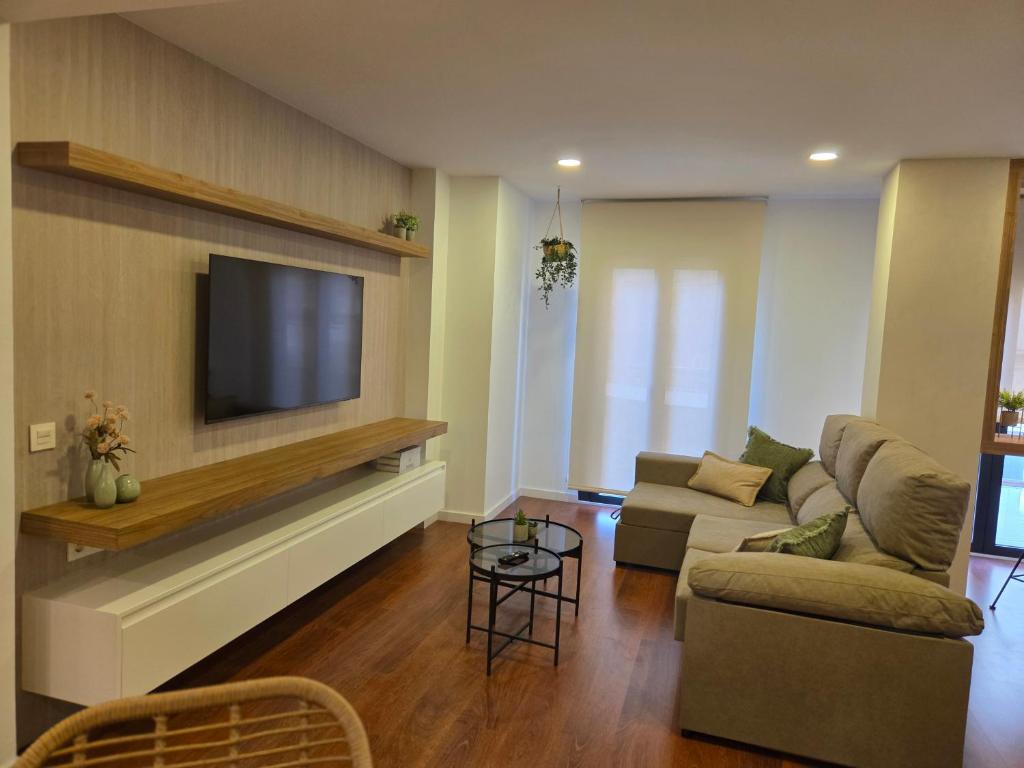 a living room with a couch and a flat screen tv at Solsuites in Almería