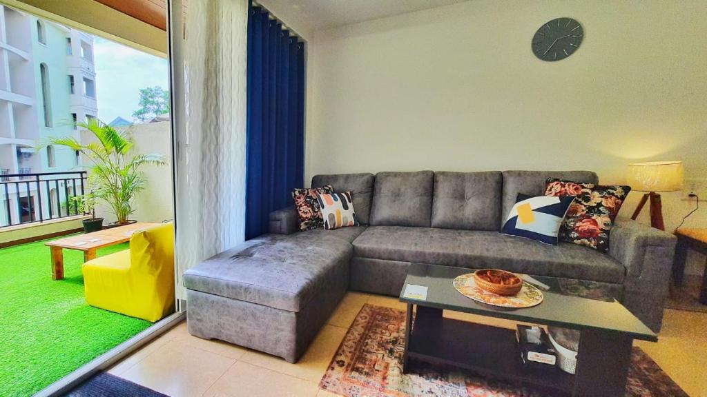 a living room with a couch and a table at Luxury Pool view Apartment w Jacuzzi by Mirabella in Mapusa