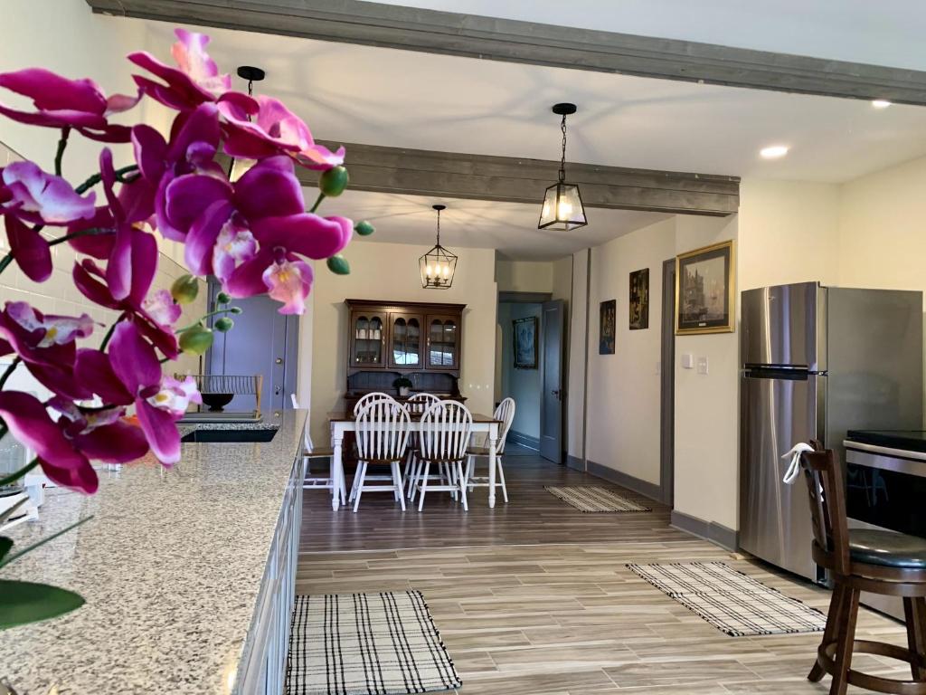 a dining room and kitchen with purple flowers at Group HQ, 9BR Near Falls, Casino & Attractions in Niagara Falls