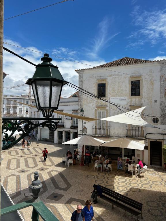 una calle con mesas y sillas y un semáforo en OMG Faro, en Faro