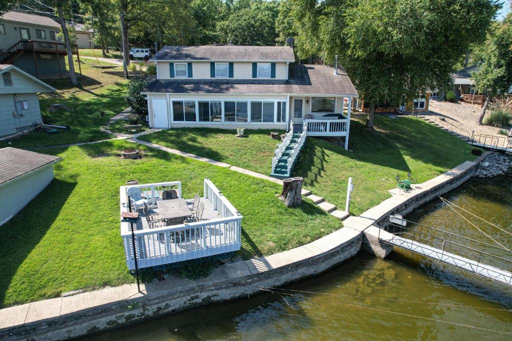 ein Haus mit einem Boot im Wasser in der Unterkunft Amazing Dock Fishing with Swim Area & Gentle Lot in Buck Creek