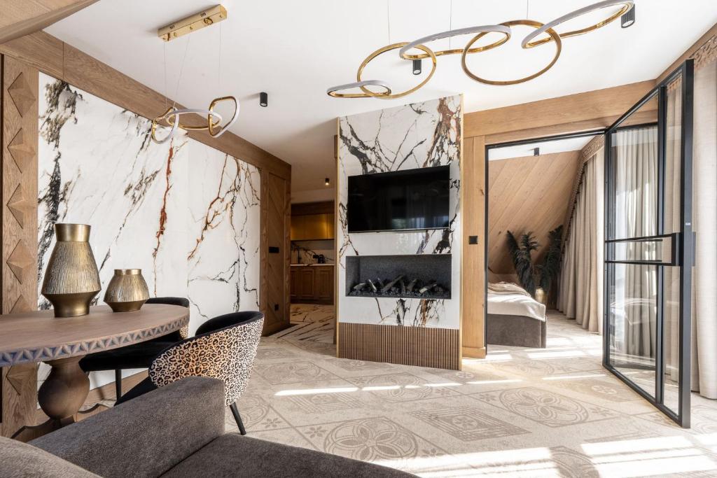 een woonkamer met een tafel en een tv bij Willa Tatrzańska Luxury Apartments & Spa in Murzasichle