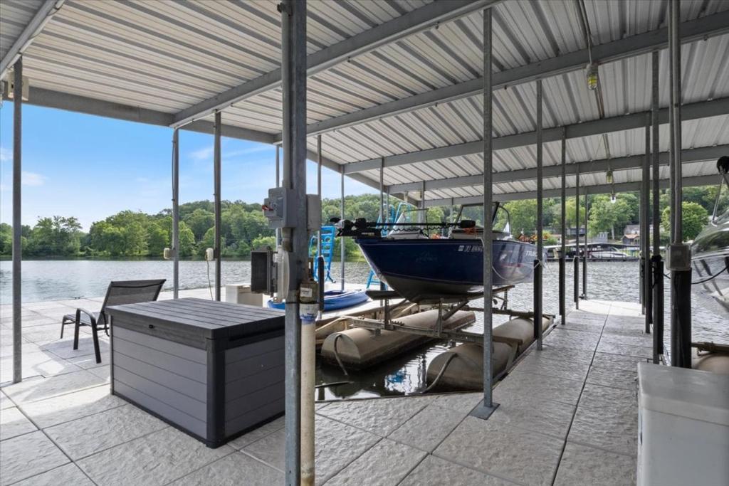 Ein Boot sitzt auf einem Dock im Wasser in der Unterkunft Gentle Sloped Lot, Private Dock, Boat Slip, Kayaks, Fire Table, Lakeview Deck, Family Friendly in Purvis