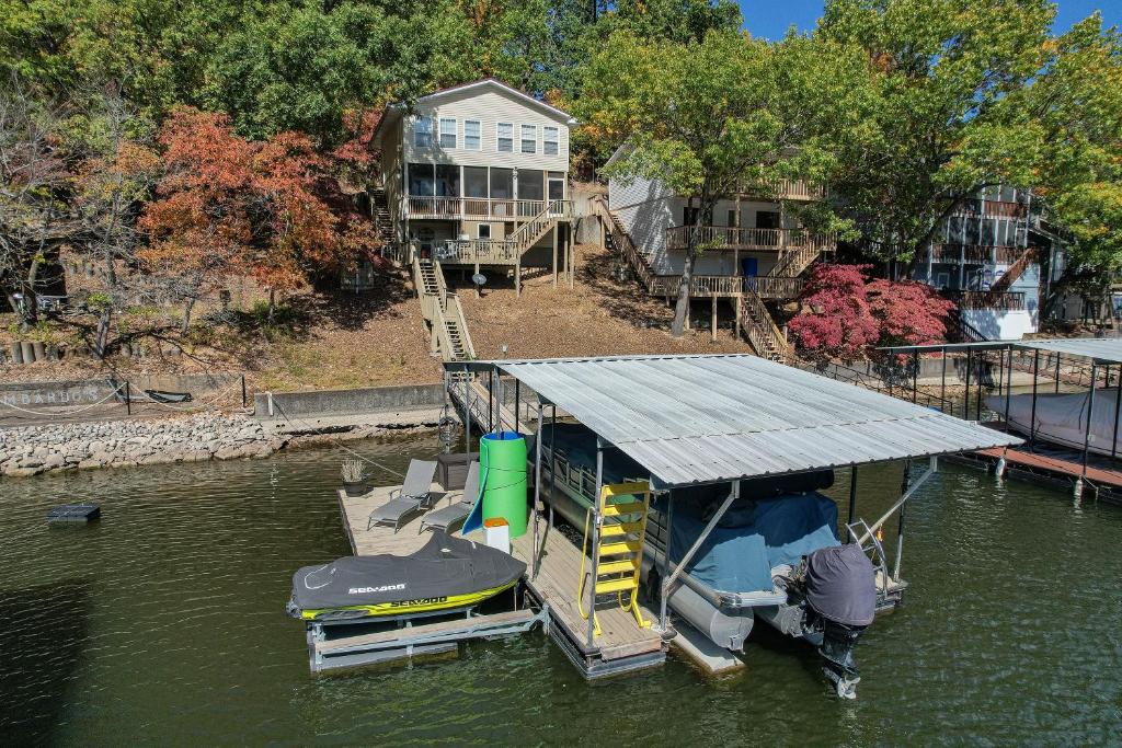 a boat with a roof in the water at Close to The Strip, Private Dock & Screened Deck! in Lake Ozark