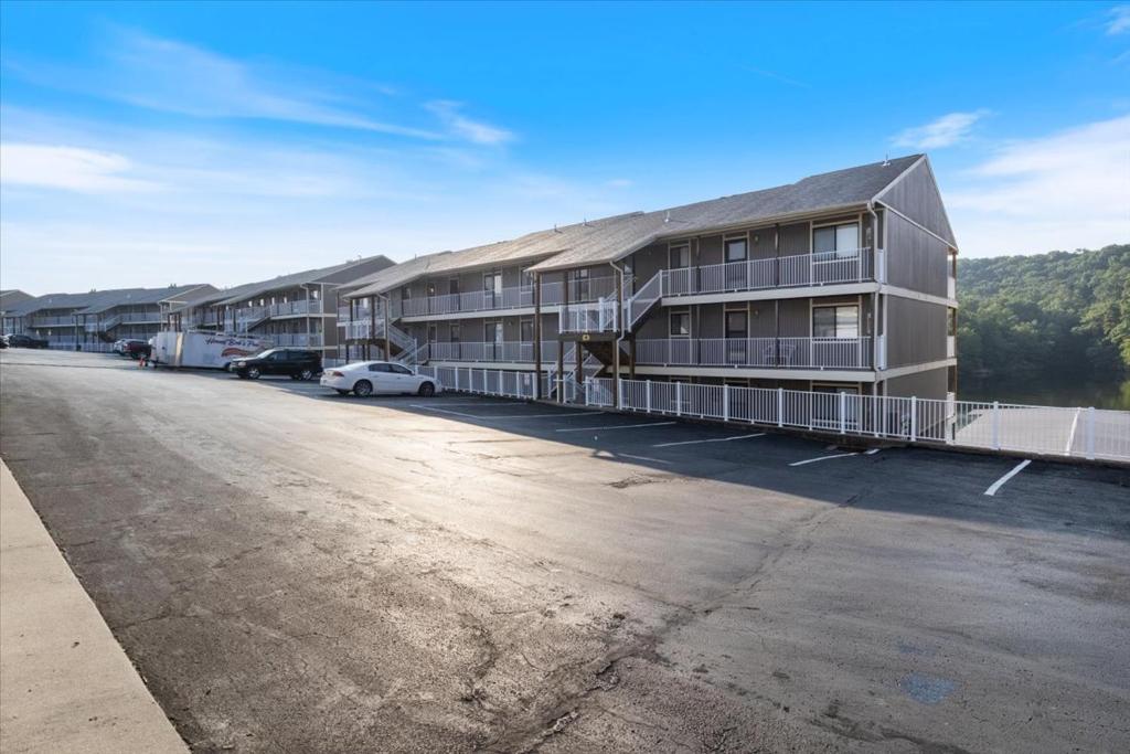 Un estacionamiento vacío frente a un edificio en Family Fun at Lake Vibin' Lazy Days Osage Beach w/ 2 Pools, Playground, Games & Calm Water, en Damsel