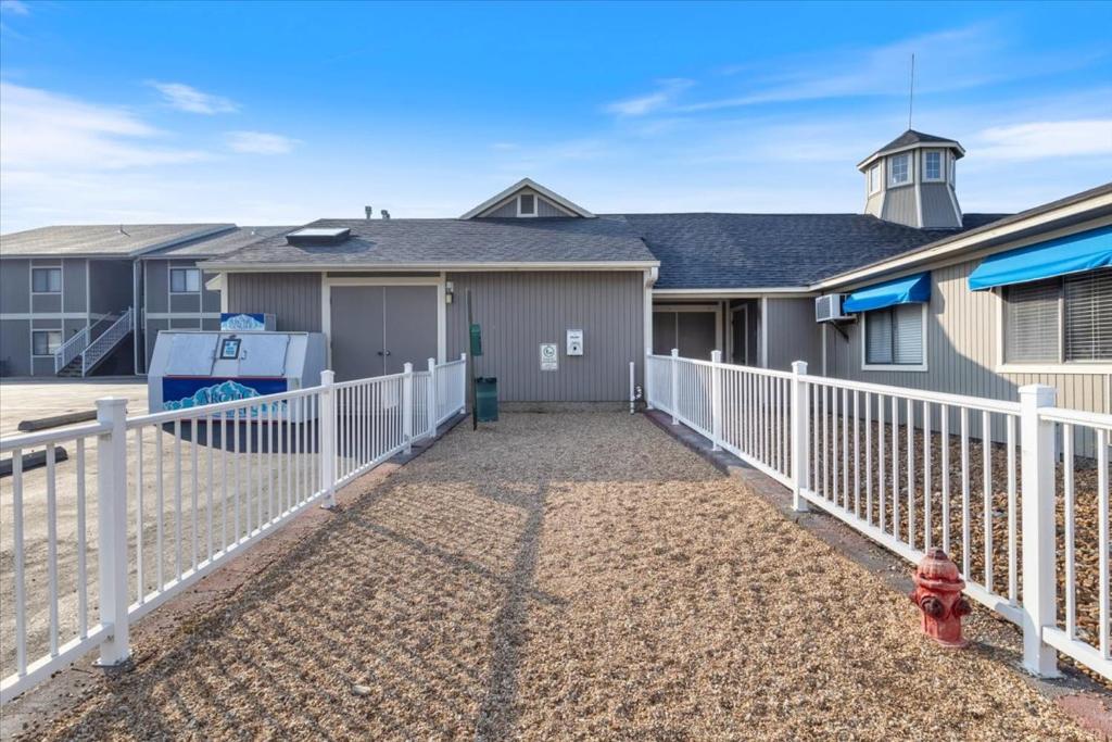 a house with a white fence and a fire hydrant at Family Fun at Lake Vibin' Lazy Days Osage Beach w/ 2 Pools, Playground, Games & Calm Water in Damsel