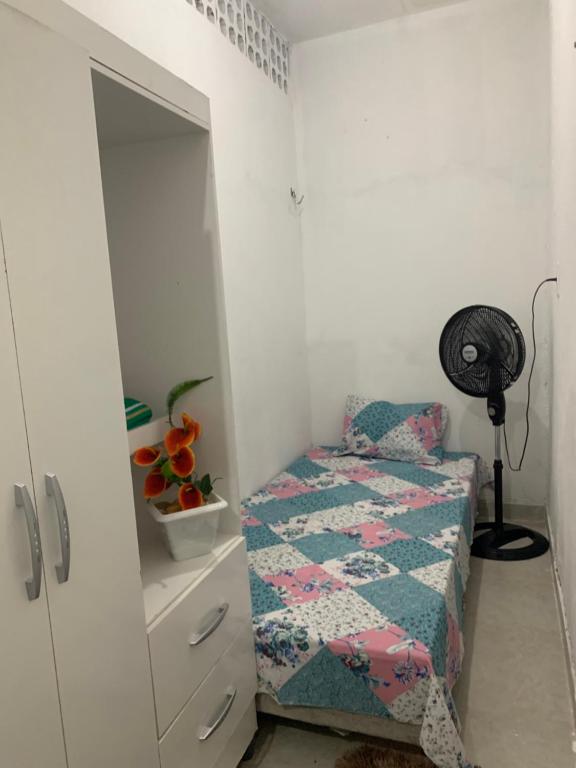 een kleine slaapkamer met een bed en een dressoir bij Kitnet Dream House 3 in Bayeux