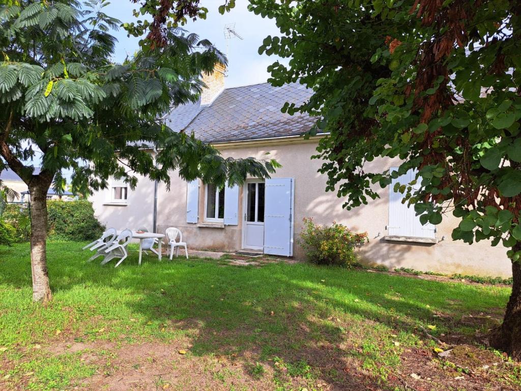 ein Haus mit einem Tisch und Stühlen im Hof in der Unterkunft Gite de campagne in Restigné