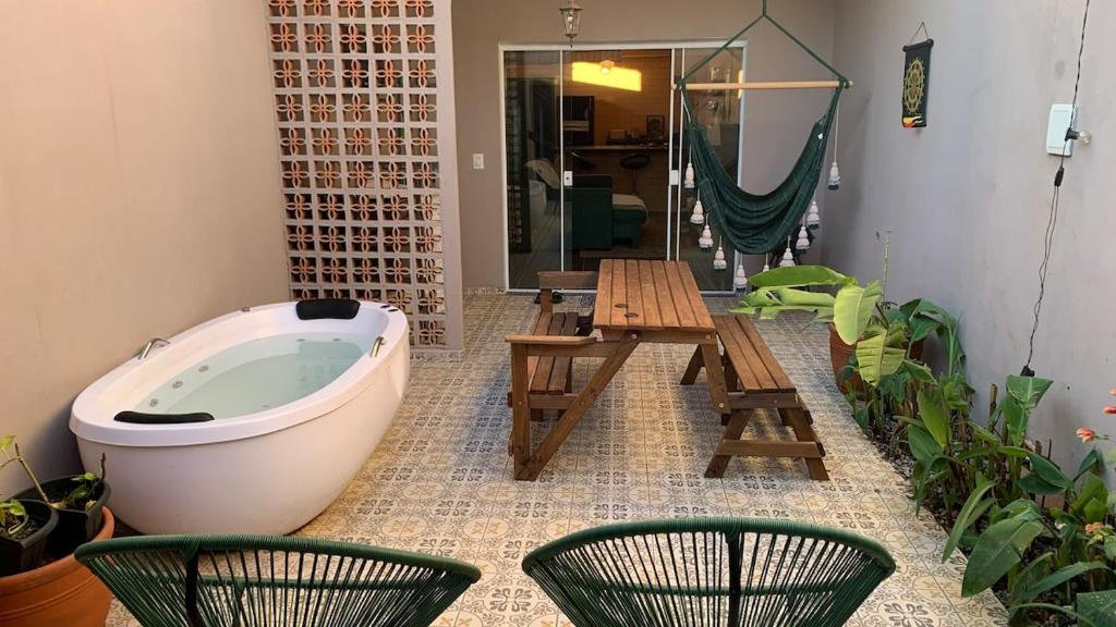 a bath tub with two chairs and a wooden table at House with Jacuzzi near São Paulo in Piracaia