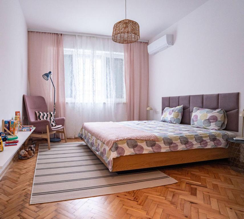 a bedroom with a large bed and a chair at Cozy in Varna in Varna City