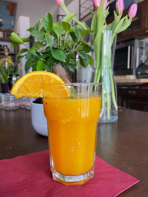 een glas sinaasappelsap op een tafel bij Villatopol Art Hostel in Rząska