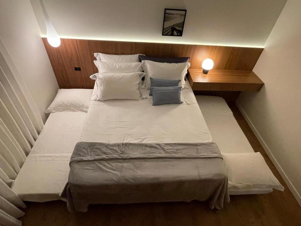 a bedroom with a large bed with white sheets and pillows at Apartamento Novo - Conforto no Saguaçú! in Boa Vista