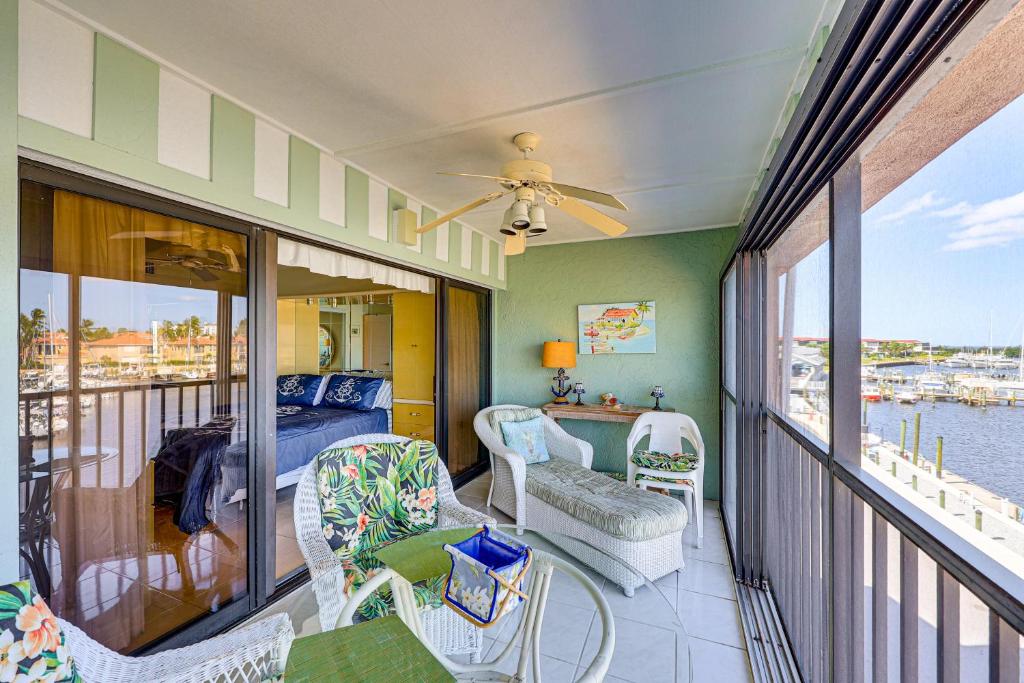 a room with a balcony with a bed and chairs at Waterfront Views and Pool Access Punta Gorda Escape in Burnt Store Marina