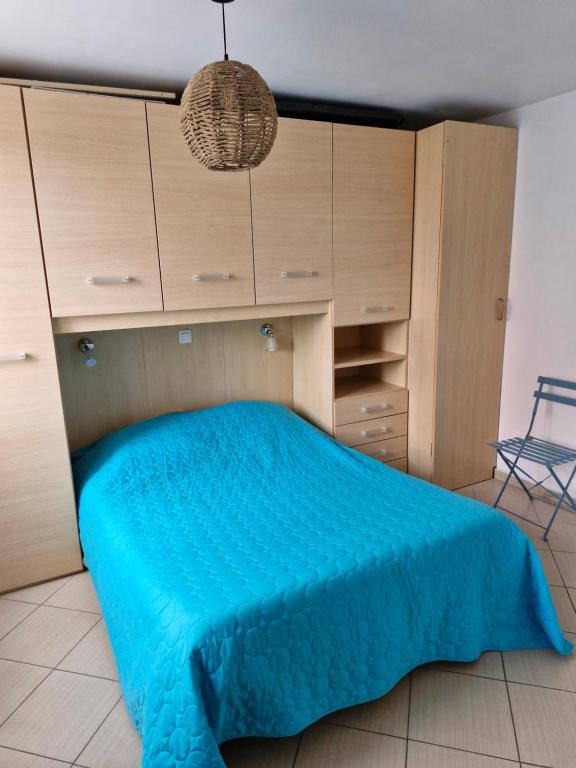 une chambre avec un lit avec un couvre-lit bleu dans l'établissement Chez Valérie et Stéphane, Les terrasses de Lozari, à Belgodère
