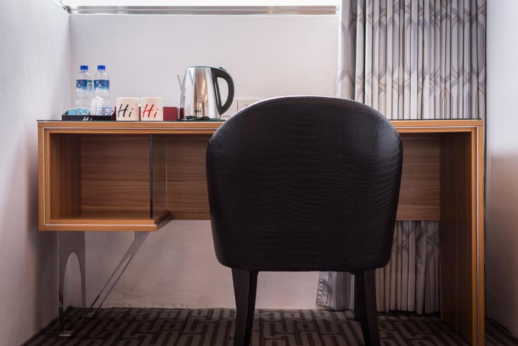 a black chair sitting in front of a desk at HOTEL HI - Xinmin in Chiayi City