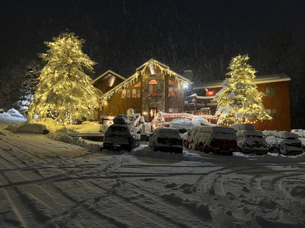 una casa decorata con luci di Natale nella neve di The Snowed Inn a Killington