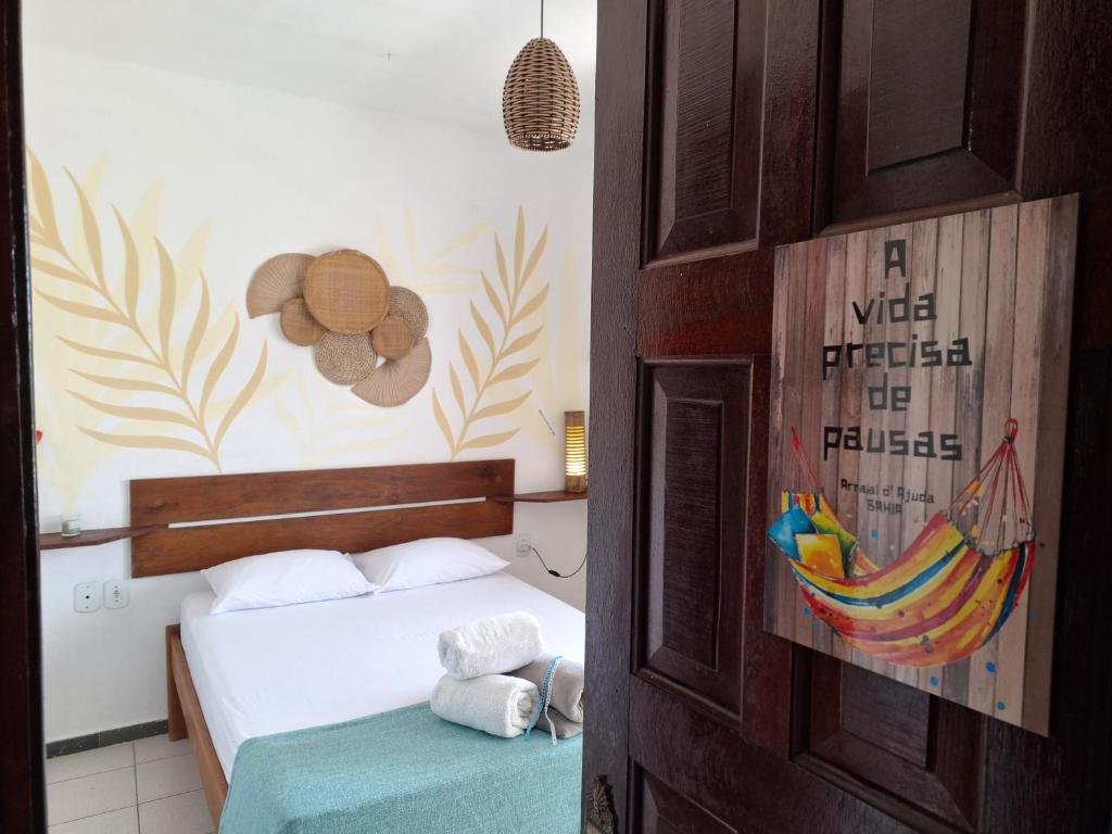 a bedroom with a bed and a sign on the wall at Odoyá Casa Hostel in Arraial d'Ajuda