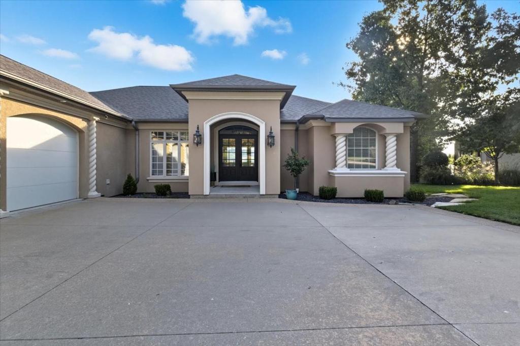 a house with a driveway in front of it at Luxury Lakefront Escape w/ Heated Pool, Hot Tub & Theater in Sunrise Beach