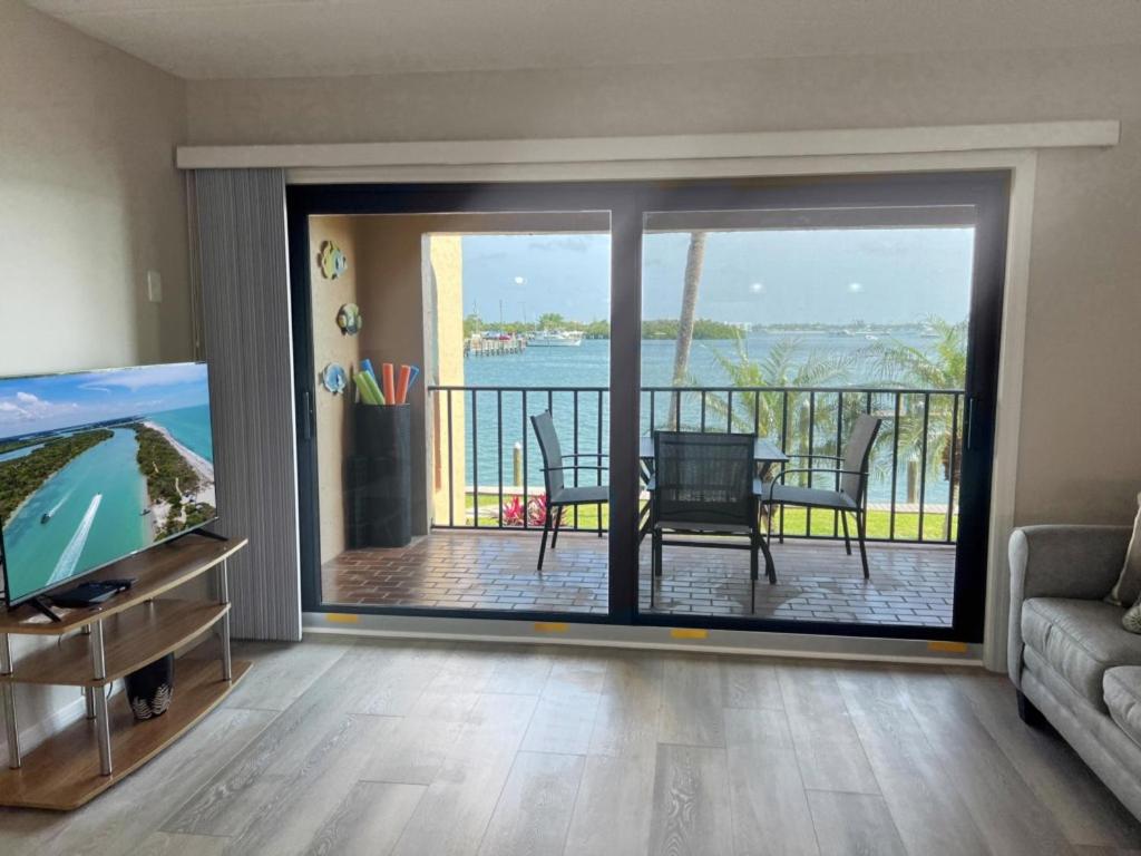 a living room with a large sliding glass door with a view of the water at El Galeon – Bay Views, Beach Access & Pool in Punta Gorda Beach