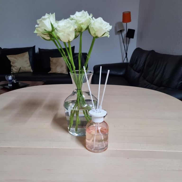 a vase with white flowers sitting on a table at Joysha's House in Ikast