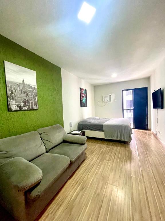 a living room with a couch and a bed at Jungle City Flat in São Vicente
