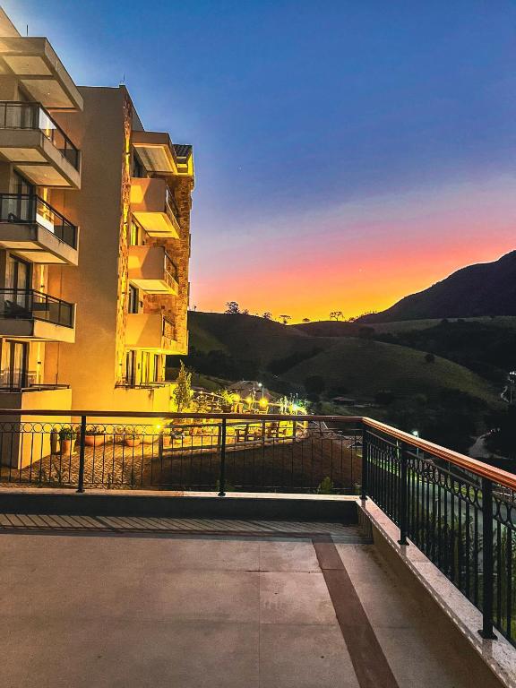 a view from the balcony of a building at sunset at Hotel Chalés Capitanias in Águas de Lindoia