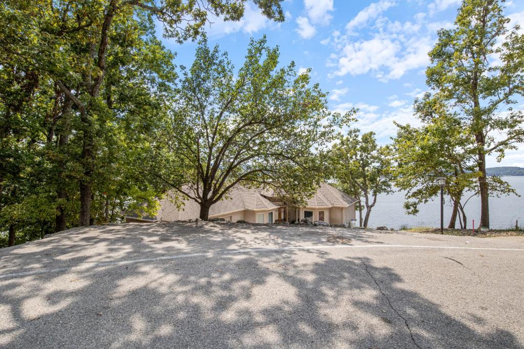 a house with a lot of trees and a driveway at Pet-Friendly Home In The Main Channel w/ Breathtaking Sunsets & Lake Views in Lake Ozark