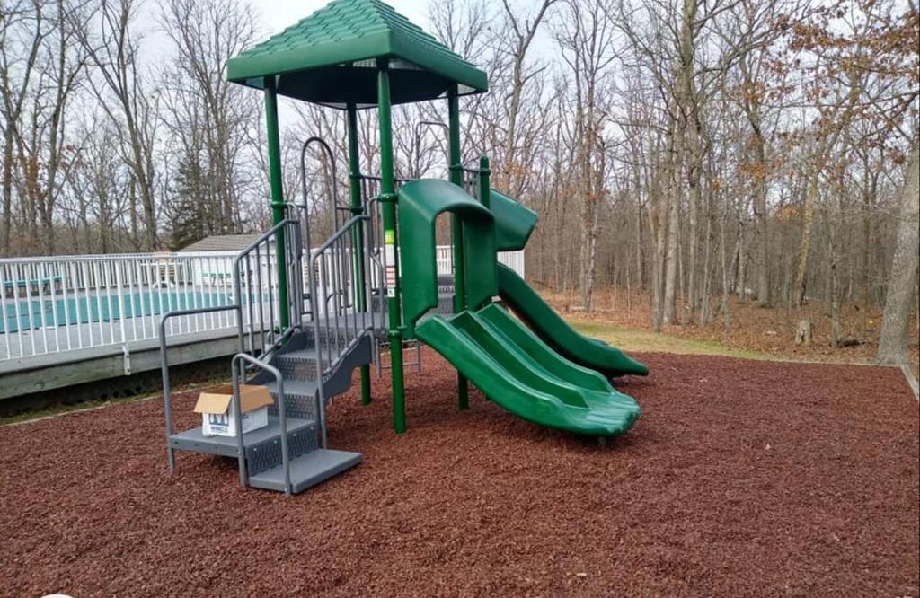 ein Spielplatz mit Rutsche in einem Park in der Unterkunft Porto Cima w/ Game Room, Dock, Boat Slip, Kayaks, Lakeside Fireplace & Hot Tub in Four Seasons