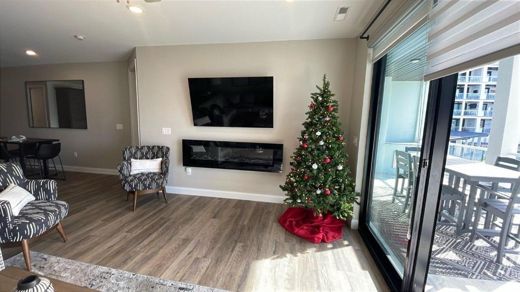 a christmas tree in a living room with a fireplace at Topsider Experience in the Heart of Osage Beach in Laguna Beach