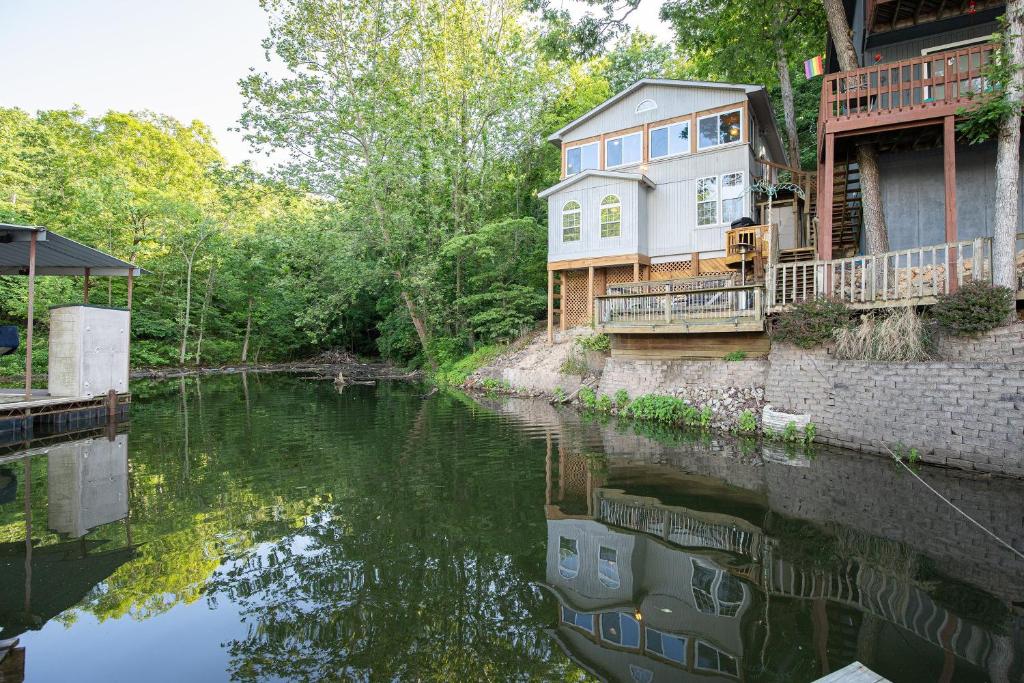 a house on the side of a river at Wonderful Remote Lake Cabin! Fish from Deck & Dock in Rocky Mount