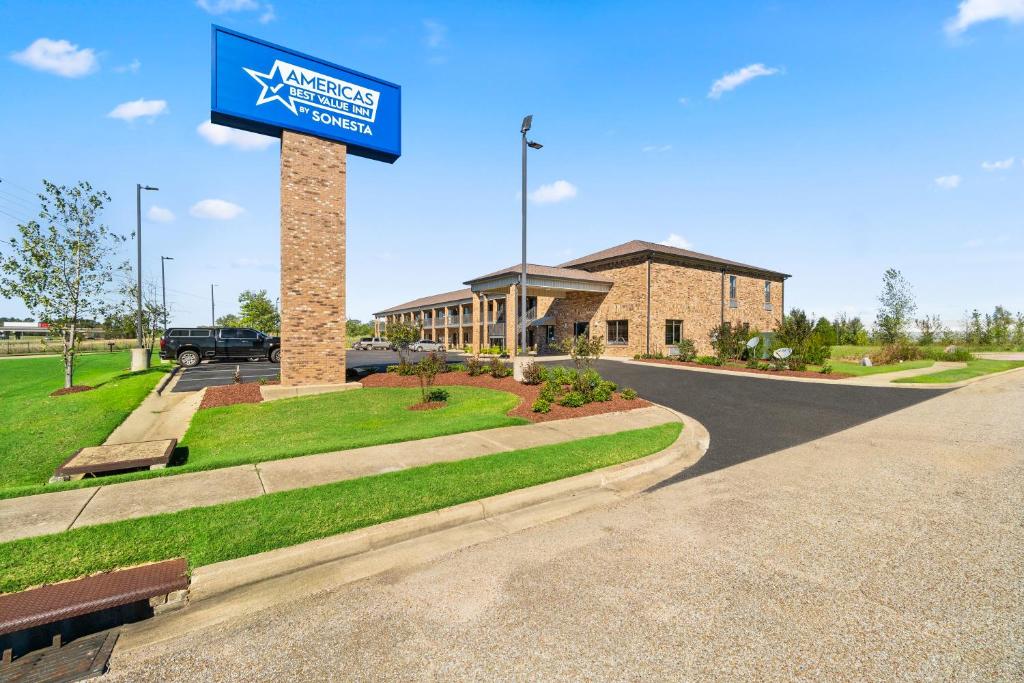 a sign on a pole in front of a building at Americas Best Value Inn Byhalia in Byhalia
